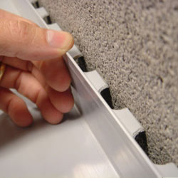A contractor in Revere installing a perimeter drain tile system during a sump pump installation.