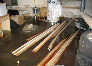 A severely flooding basement in Haverhill, with lumber and personal items floating in a foot of water