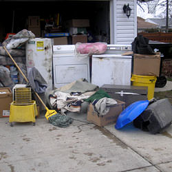 Soaked, wet personal items sitting in a driveway, including a washer and dryer in Framingham.