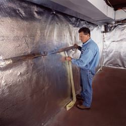 Installation of a radiant heat and vapor barrier on a basement wall in Andover